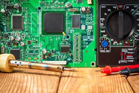 Services for the production of electronics and repair of electronic boards. Wooden background.の写真素材