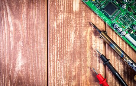 Services for the production of electronics and repair of electronic boards. Wooden background.