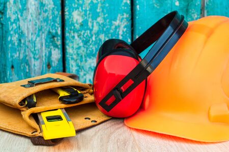 Protective equipment and tools in a bag for the builder on a blue vintage wooden