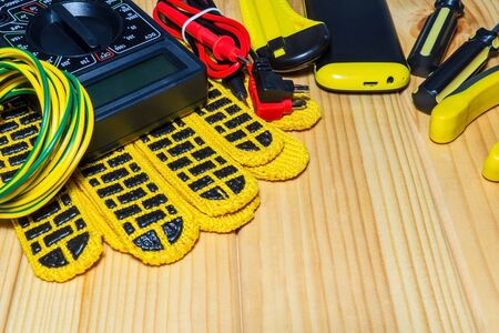 Tools and spare parts for electrician - wiring, tester, screwdrivers on wooden boards.