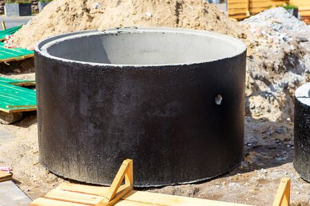 Installation of concrete sewer wells in the ground at the construction site.