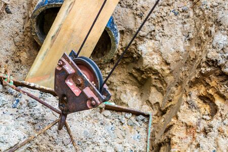 The digging of the well, the crane hook lifts the ground from the hole in the box.