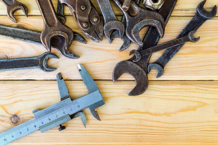 Rusty old tools are laid out on a wooden