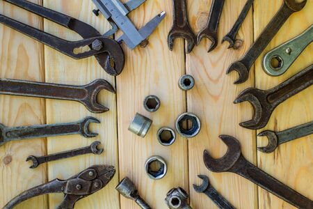 Rusty old tools are laid out on a wooden