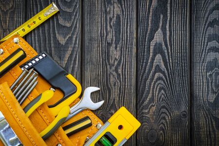 Tools in the bag for carpentry and accessories. Set for the master on a wooden black vintage
