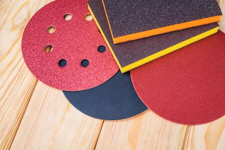 Set of abrasive tools and sandpaper on wooden background. The wizard is used for grinding items.の写真素材