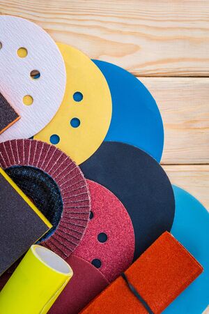 Set of abrasive tools different colors and sandpaper on vintage wooden background. The wizard is used for grinding itemsの写真素材