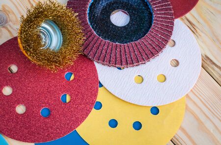 Set of abrasive tools different colors and sandpaper on black vintage wooden background. The wizard...