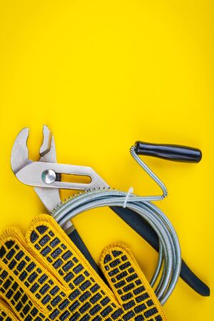 Plumbing tools, cable and gloves for connecting water hoses on yellow backgroundの写真素材