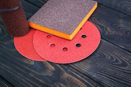 Set of abrasive tools different colors and sandpaper on black vintage wooden background. The wizard is used for grinding itemsの写真素材