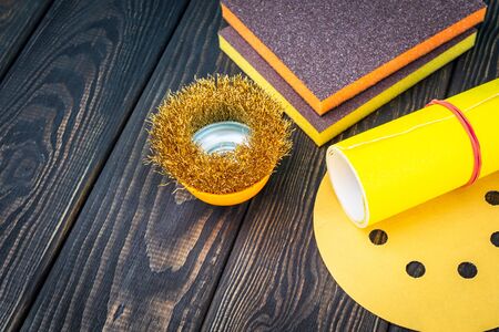 Set of abrasive tools different colors and sandpaper on black vintage wooden background. The wizard is used for grinding itemsの写真素材