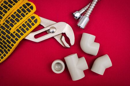 Plumbing tools, cable for connecting water hoses on red backgroundの写真素材