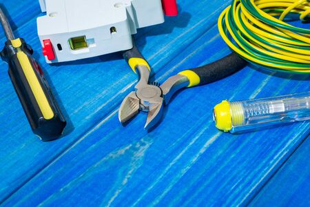 Tools and spare parts for master electrician on blue wooden boards