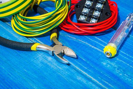 Tools and spare parts for master electrician on blue wooden boards