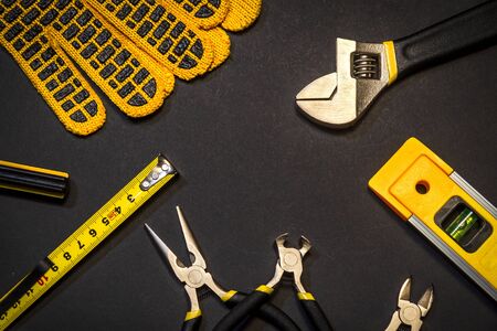 Tools for master builder prepared before work on black background with place for advertising