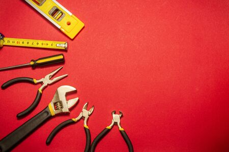 Tools for master builder prepared before work on red background with place for advertisingの写真素材