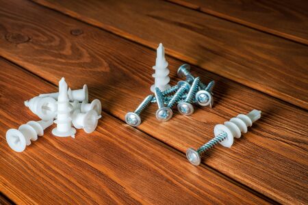 Screws with plastic nozzles for the craftsman on brown wooden vintage backgroundの写真素材
