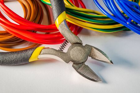 Pliers tool and wires for electrician closeup on gray backgroundの写真素材