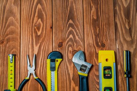 Tools for master builder prepared before work on a brown wooden boards