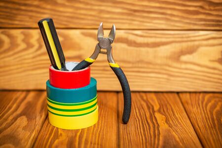 Insulating tape and tools for electrician on vintage wooden boards closeup