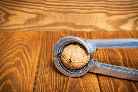 Tongs chop nut on an old vintage table before cooking dessertsの写真素材