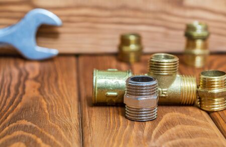 Set of brass fittings is often used to connect for water and gas installations on the background of toolの写真素材