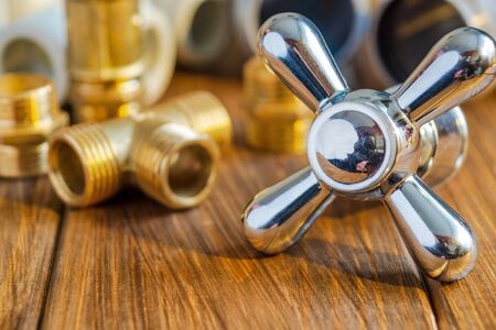 Spare parts with copper and plastic accessories for plumbing repair on vintage wooden boardsの写真素材