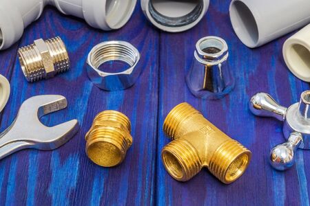 Spare parts with copper and plastic accessories for plumbing repair on wooden blue boards