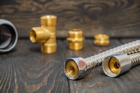 The water silver metal hose with connecting nuts and fittings in the background on black boardsの写真素材