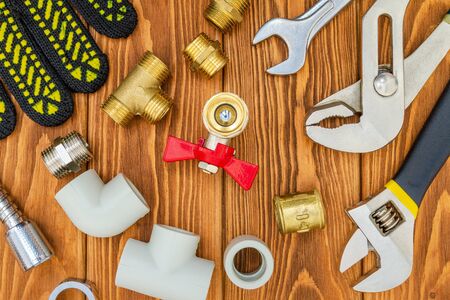 New spare parts and tools for plumbing repair on a vintage wooden boardsの写真素材