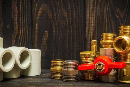 Spare parts with copper and plastic accessories for plumbing repair on dark vintage wooden boardsの写真素材