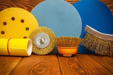 Set of abrasive tools different colors and yellow sandpaper on vintage wooden boards, wizard is used for grinding itemsの写真素材