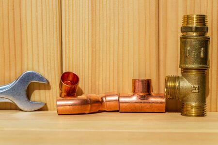 Spare parts with copper and plastic accessories for plumbing repair on wooden boardsの写真素材