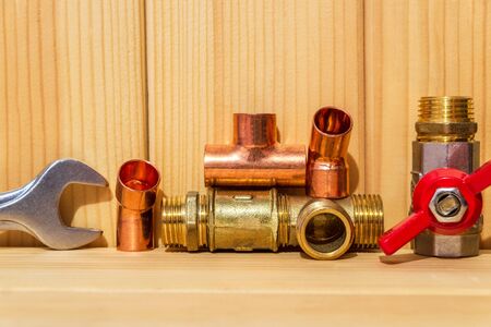 Spare parts with copper and plastic accessories for plumbing repair on wooden boardsの写真素材