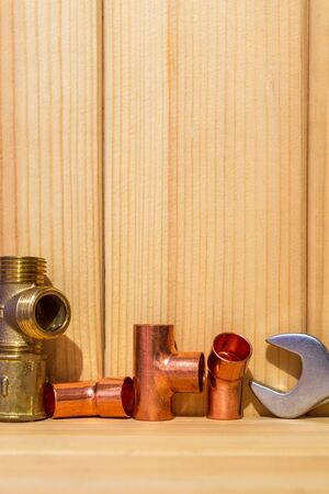 Spare parts with copper and plastic accessories for plumbing repair on wooden boardsの写真素材