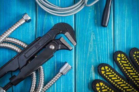Necessary set of tools and hose for master plumber on blue wooden boardsの写真素材