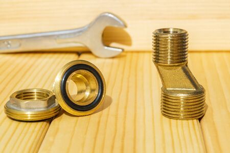 View plumbing tools brass pipe connectors on wooden board close up prepared for repairの写真素材