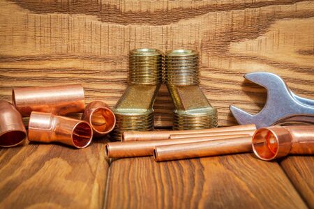 Spare parts with copper and brass accessories for plumbing repair on vintage wooden boards