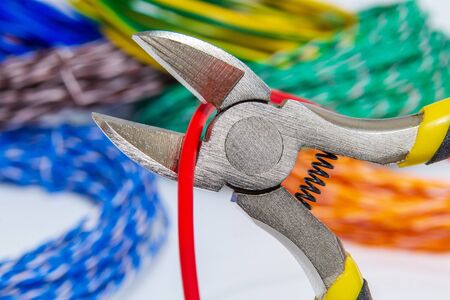 Pliers tool cutting red electric wire closeup service and repairing conceptの写真素材