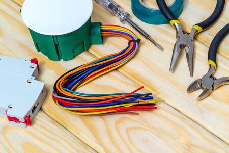 Electrical junction box with wires and tool on wooden boards usually used in the electric...