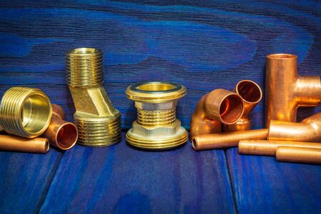 Copper water pipe fittings for soldering plumbing concept or repair water supply on blue wooden...