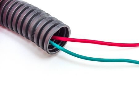 Corrugated pipe with green and red cables isolated on white background, electrical installation and...