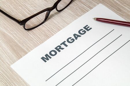 Mortgage agreement form with pen and glasses on table in the bank officeの写真素材