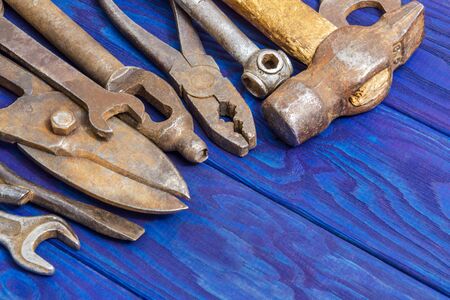 Many vintage craftsman tools stacked after work on blue wooden boardsの写真素材