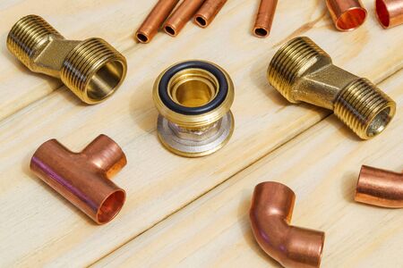 Copper water pipe fittings for soldering plumbing concept or repair water supply on vintage wooden boardsの写真素材