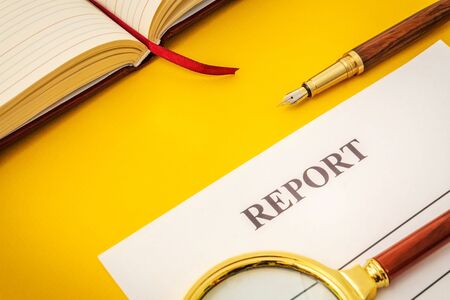Blank form and pen for drawing up report on yellow table in the officeの写真素材