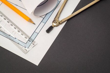 Rolled house diagrams and accessories for drawing lying on construction drawing. Drawings and...