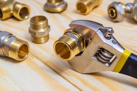 Plumbing fitting and adjustable spanner on a wooden boards during repair or replacement of spare partsの写真素材