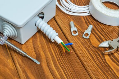 Tools and accessories used in electrical installation or repair on wooden workshop tableの写真素材