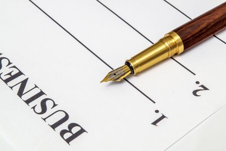Stylish pen lies on a business plan form in front of notes